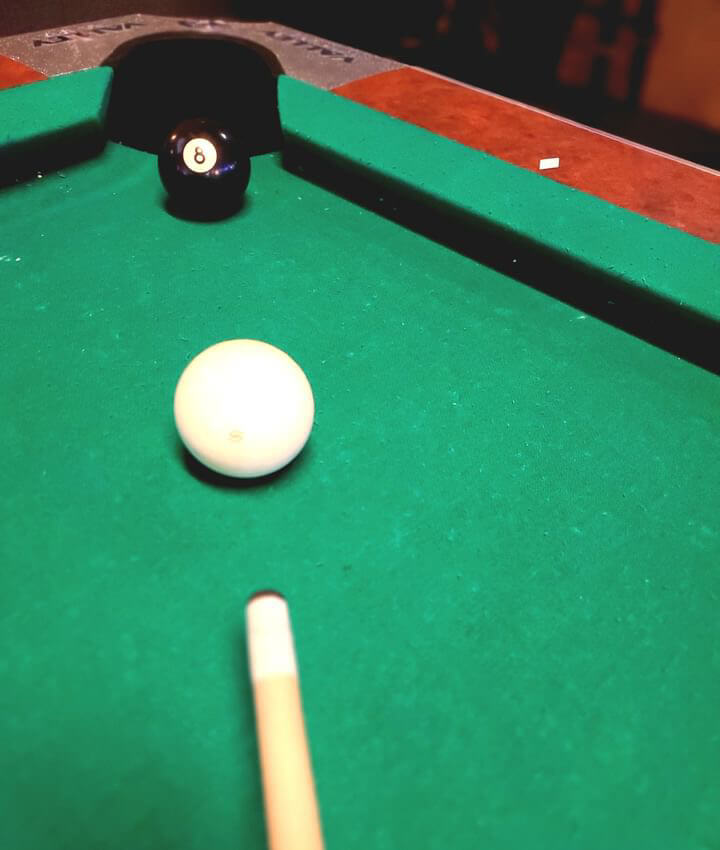 8-ball and cue ball on the pool table at Louise's dive bar Lawrence