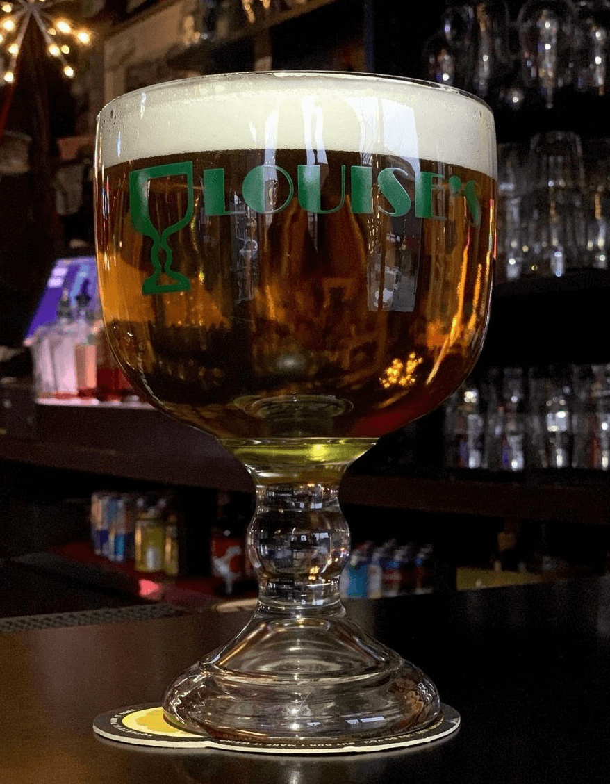 Louise's branded schooner filled with beer at the bar — best bar in Lawrence KS